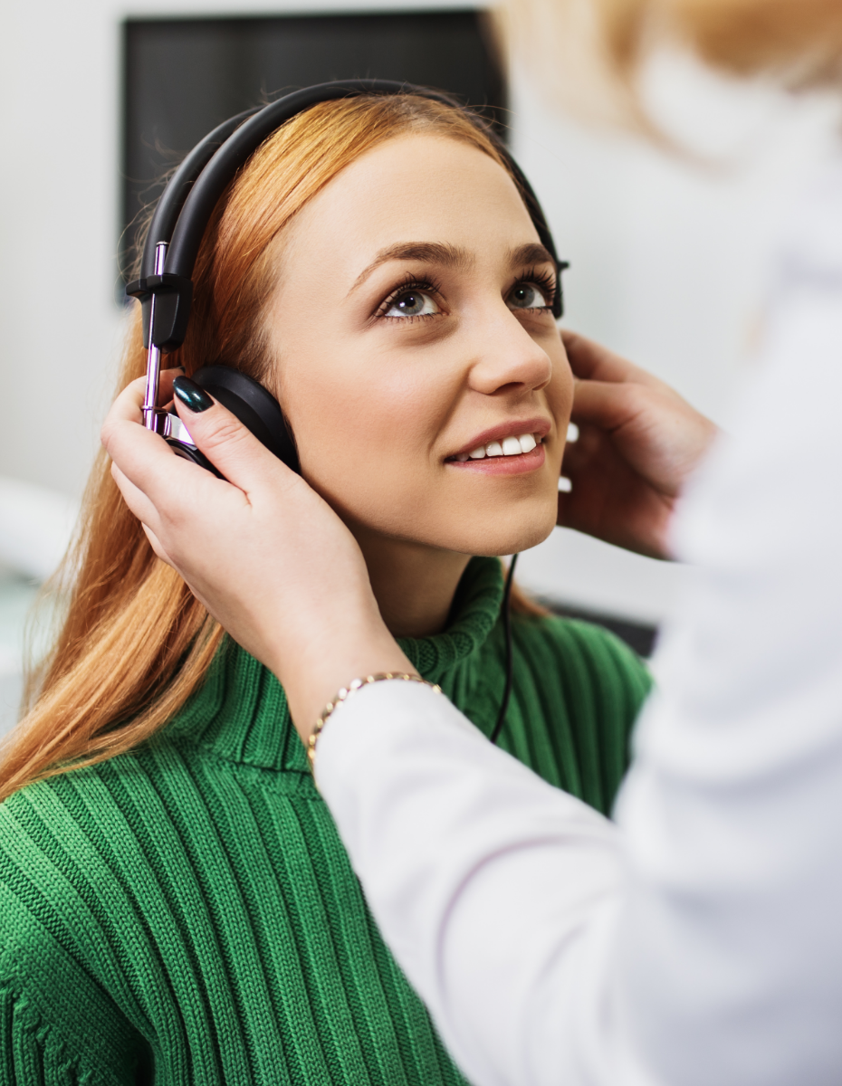 Frau mit Kopfhörern beim Hörtest.