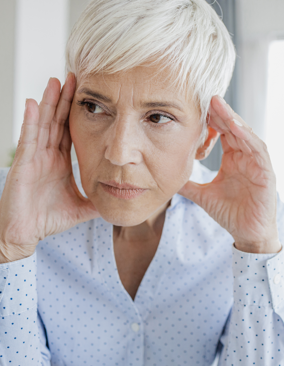 Frau greift sich mit beiden Händen an den Kopf, wegen des störenden Ohrgeräuschs. 