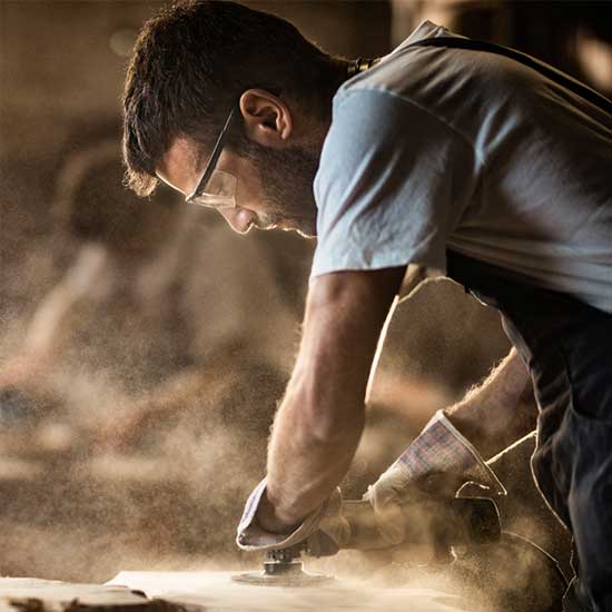 Mann beim Schleifen mit lauten Maschinen.
